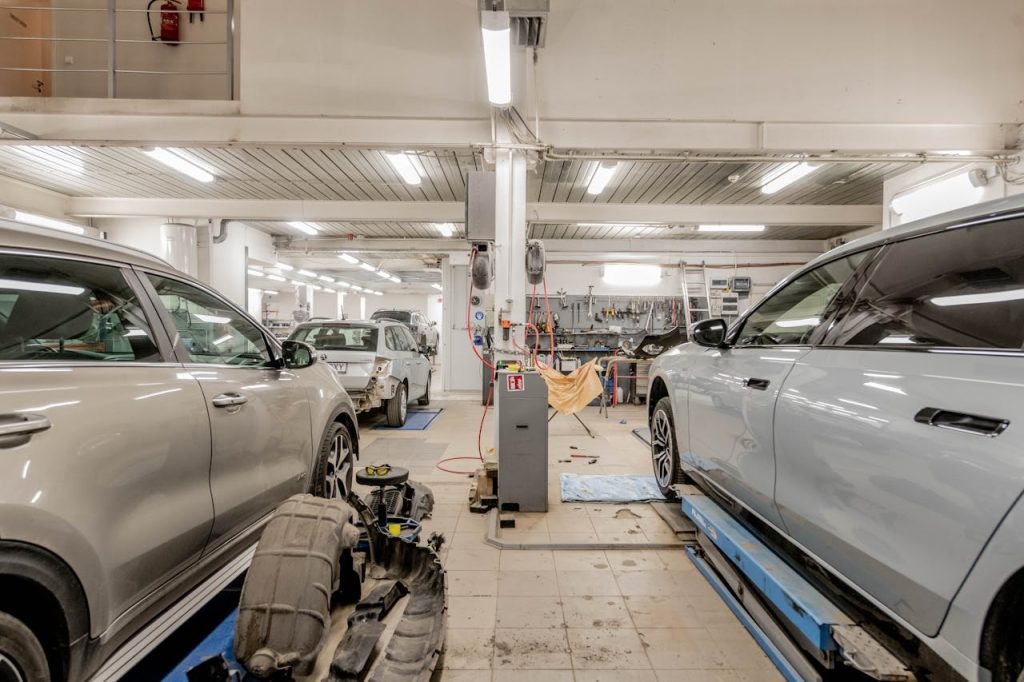 Interior of an automotive repair shop with cars undergoing maintenance and servicing.